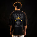 Person wearing a black t-shirt with a graphic design and text on the back against a dark background