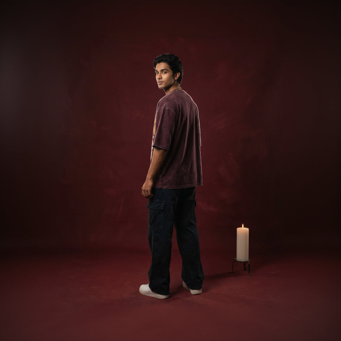 Man standing in a dark room with a candle on a red background