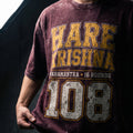 Person wearing a maroon t-shirt with 'HARE KRISHNA' text and number '108'