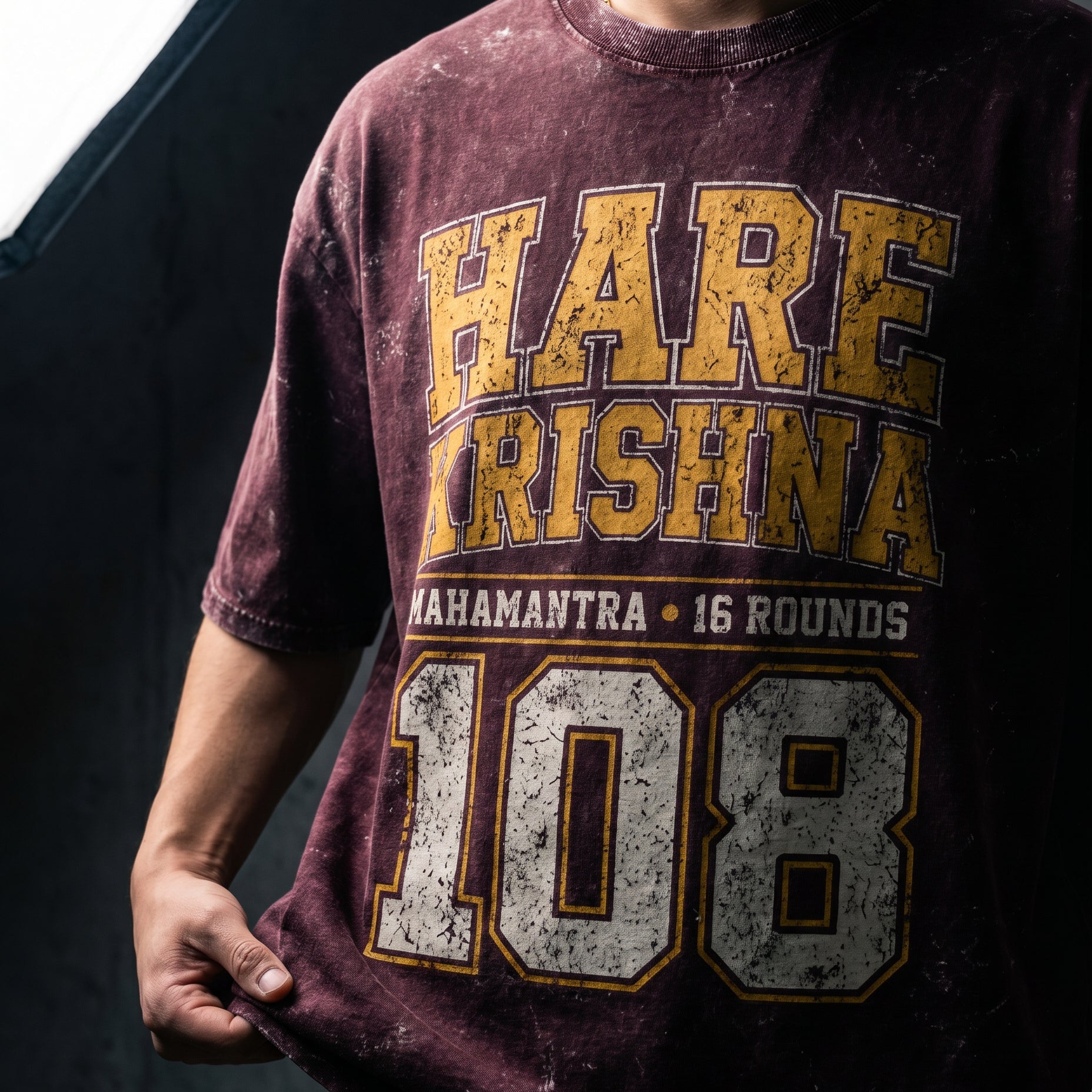 Person wearing a maroon t-shirt with 'HARE KRISHNA' text and number '108'